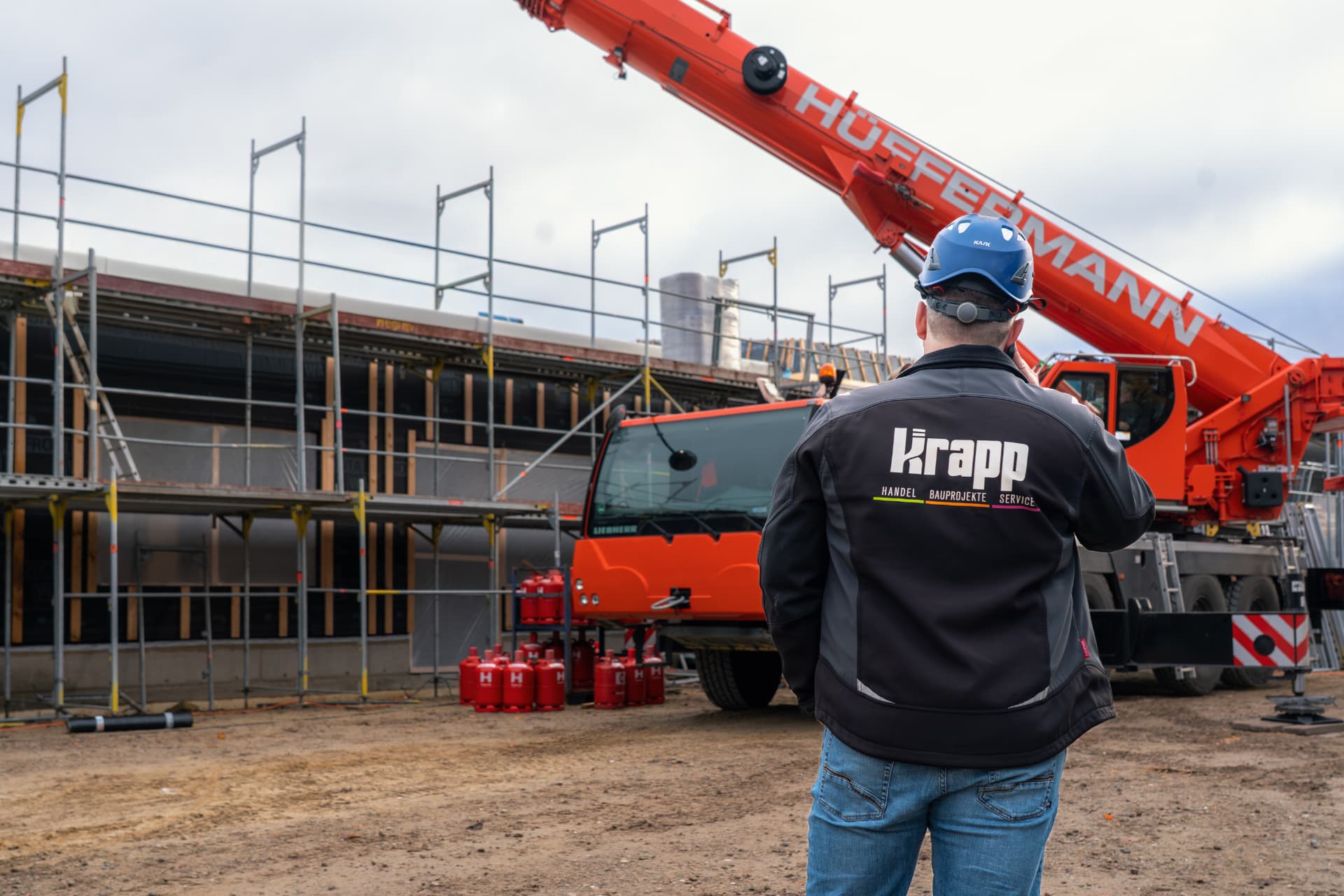 Krapp-Mitarbeiter koordiniert einen Kraneinsatz auf einer Baustelle