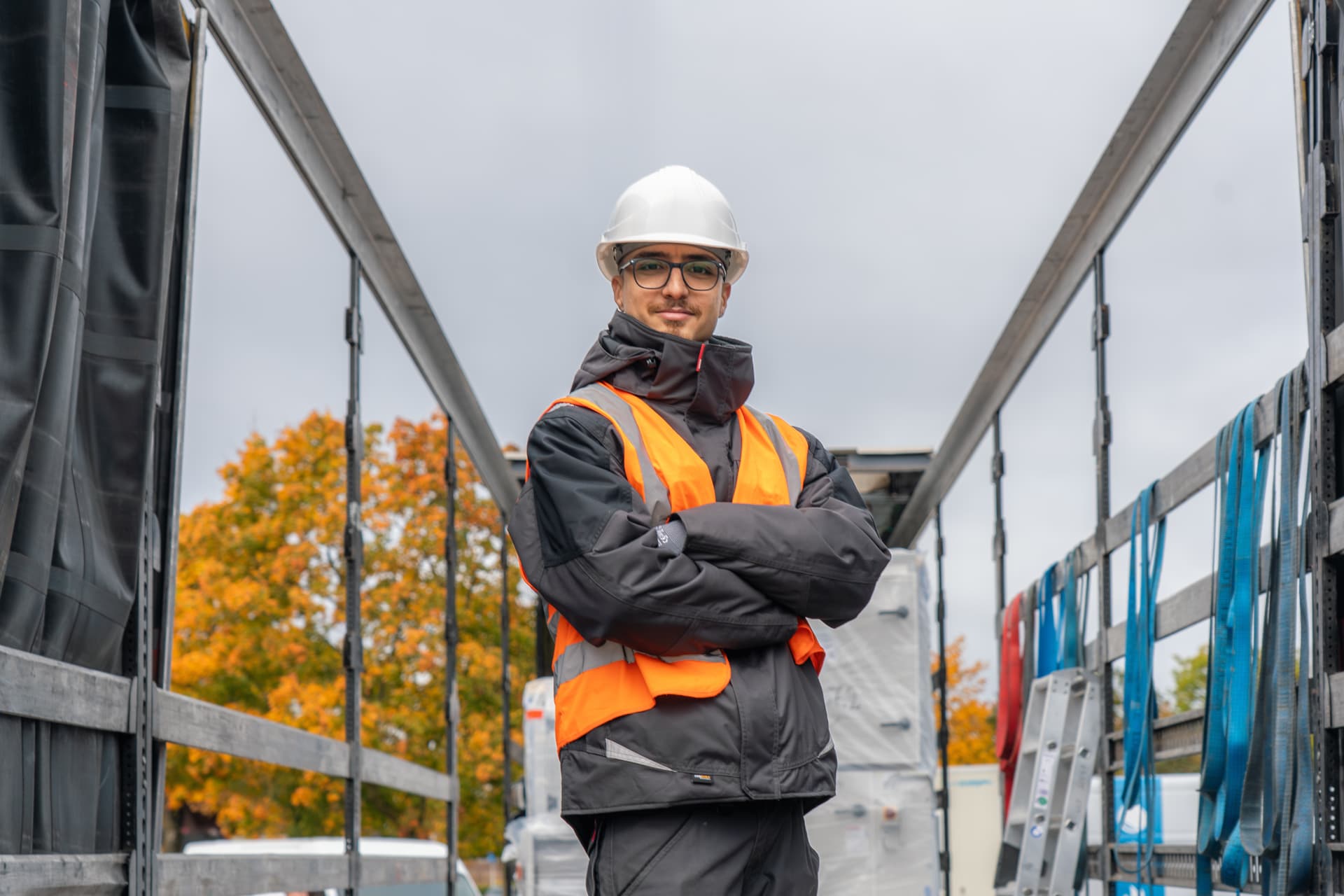 Krapp-Mitarbeiter mit Helm und Warnweste am beladenen Materialanhänger